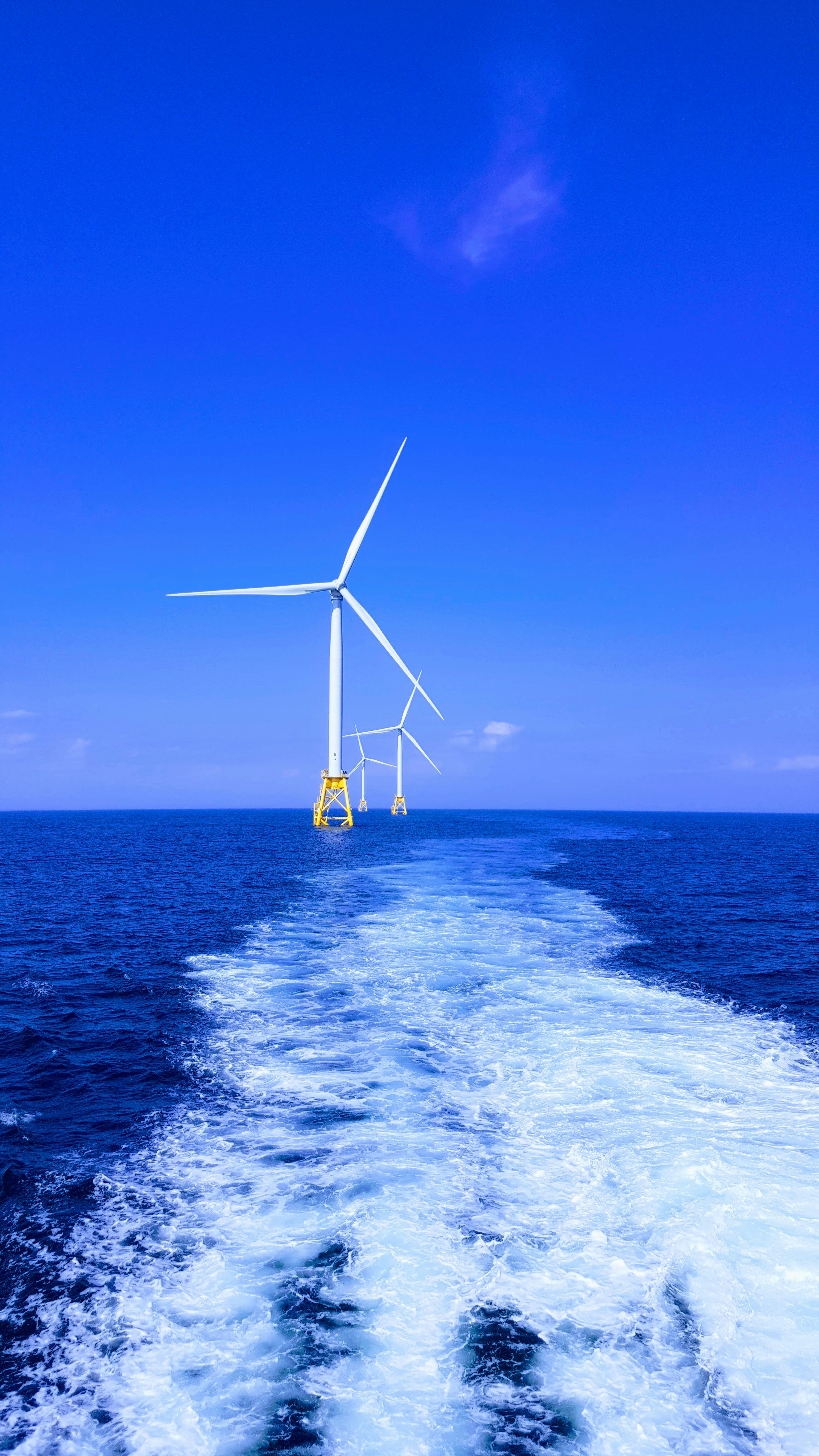 Offshore wind turbines across bright blue water
